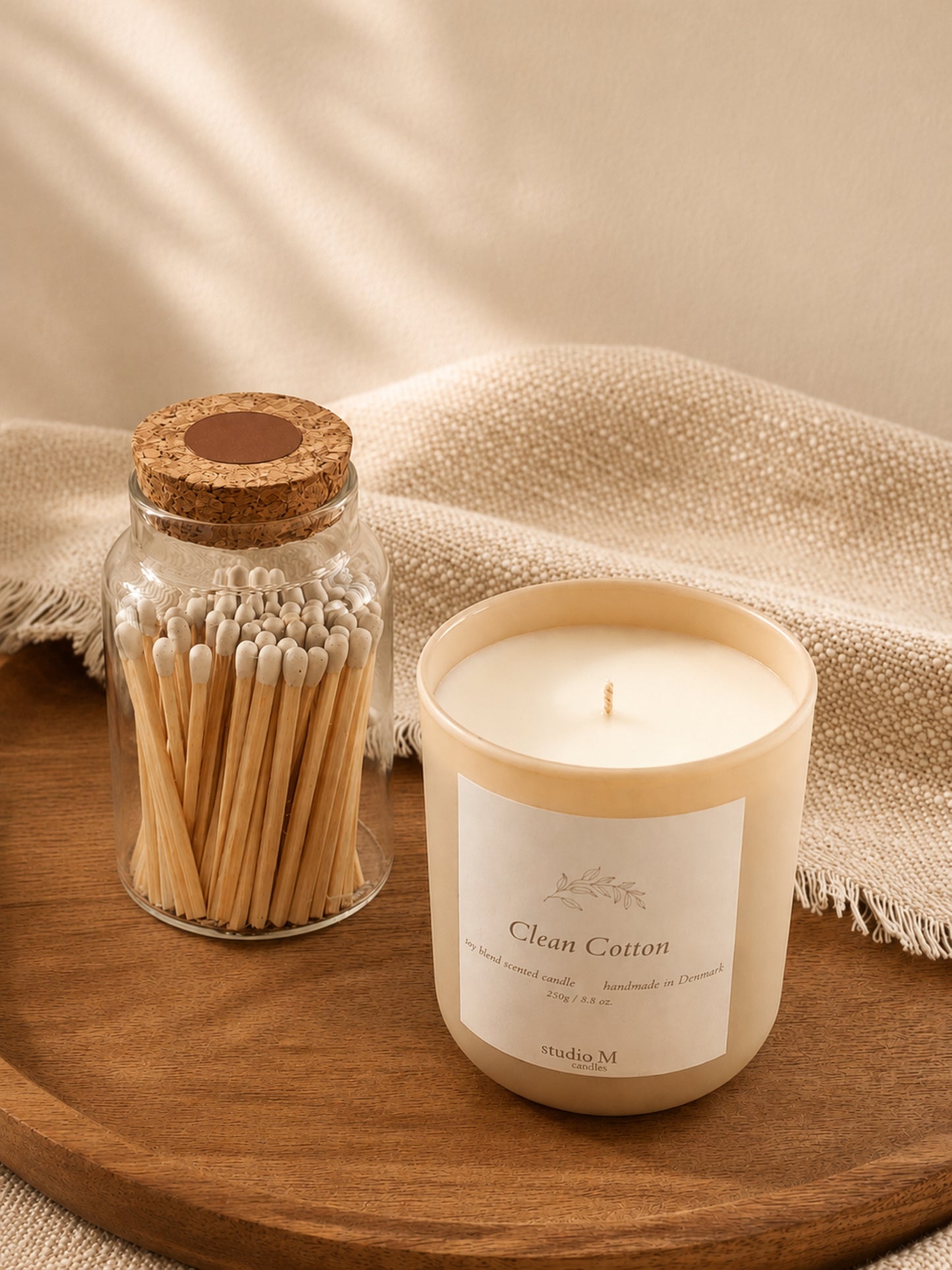 Clean Cotton Duftkerze mit Streichholzglas auf Holztablett