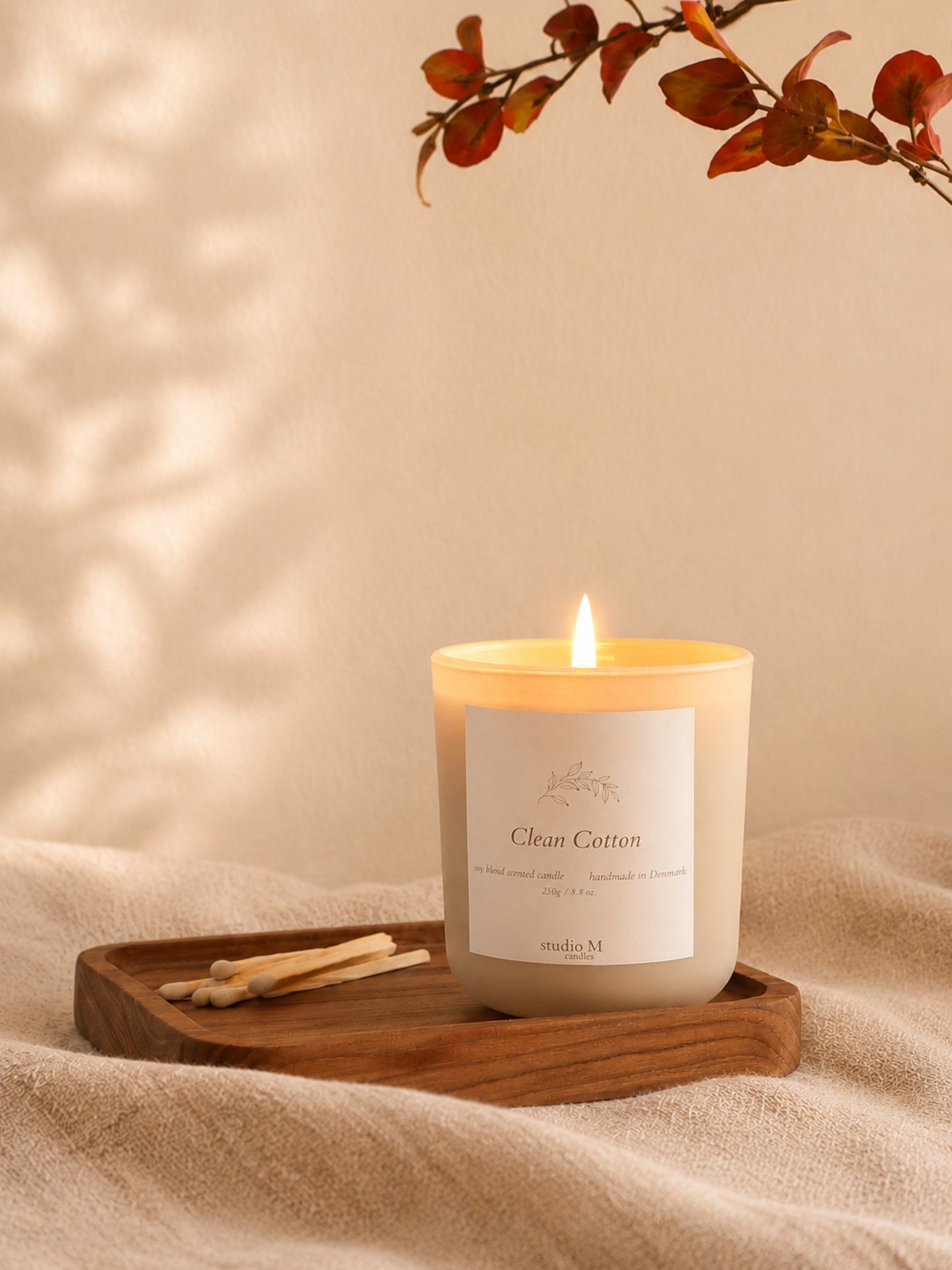 Brennende Clean Cotton Duftkerze auf Holztablett