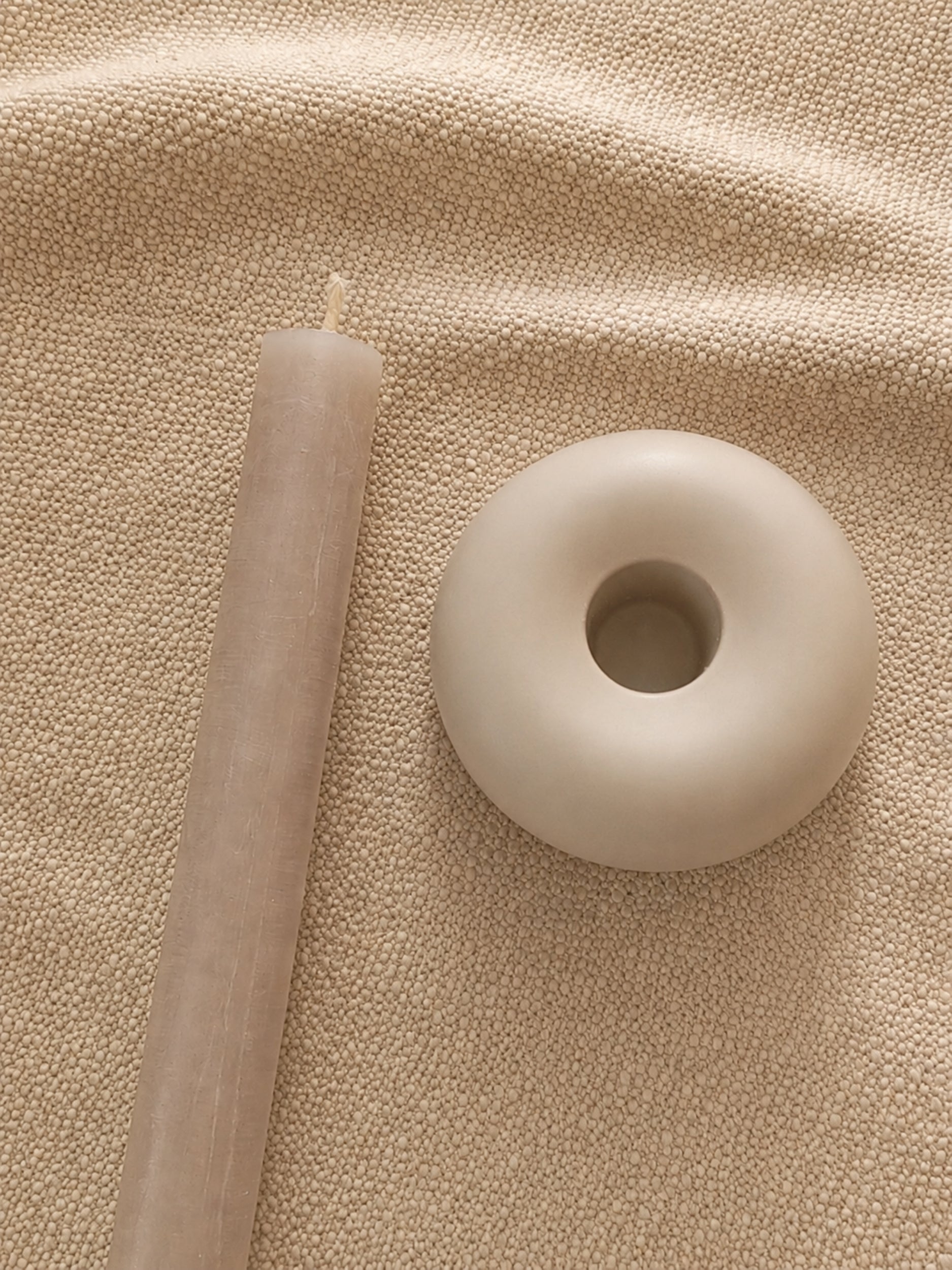 Kerzenhalter "Ring" aus Porzellan in der Draufsicht neben einer Stabkerze