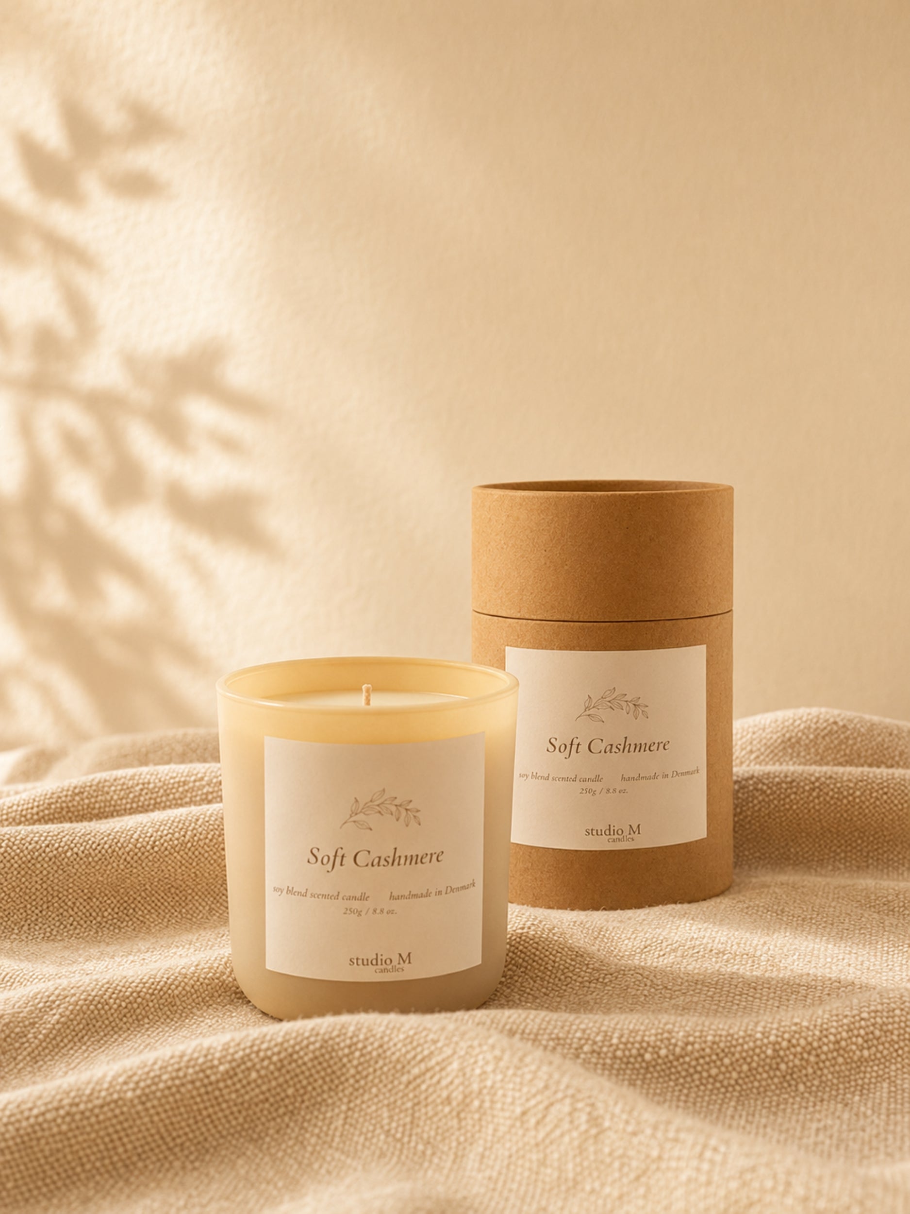 Soft Cashmere Duftkerze im Glas mit passender Verpackung auf hellem Stoff