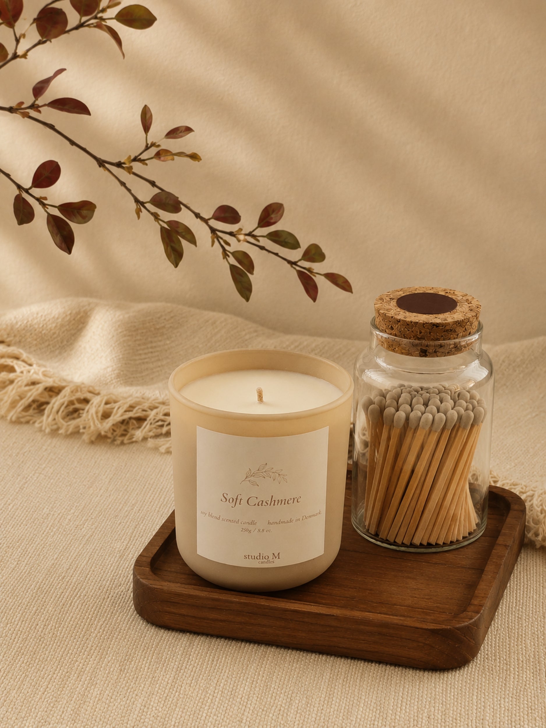 Duftkerze "Soft Cashmere" und Streichholzglas auf Naturholztablett